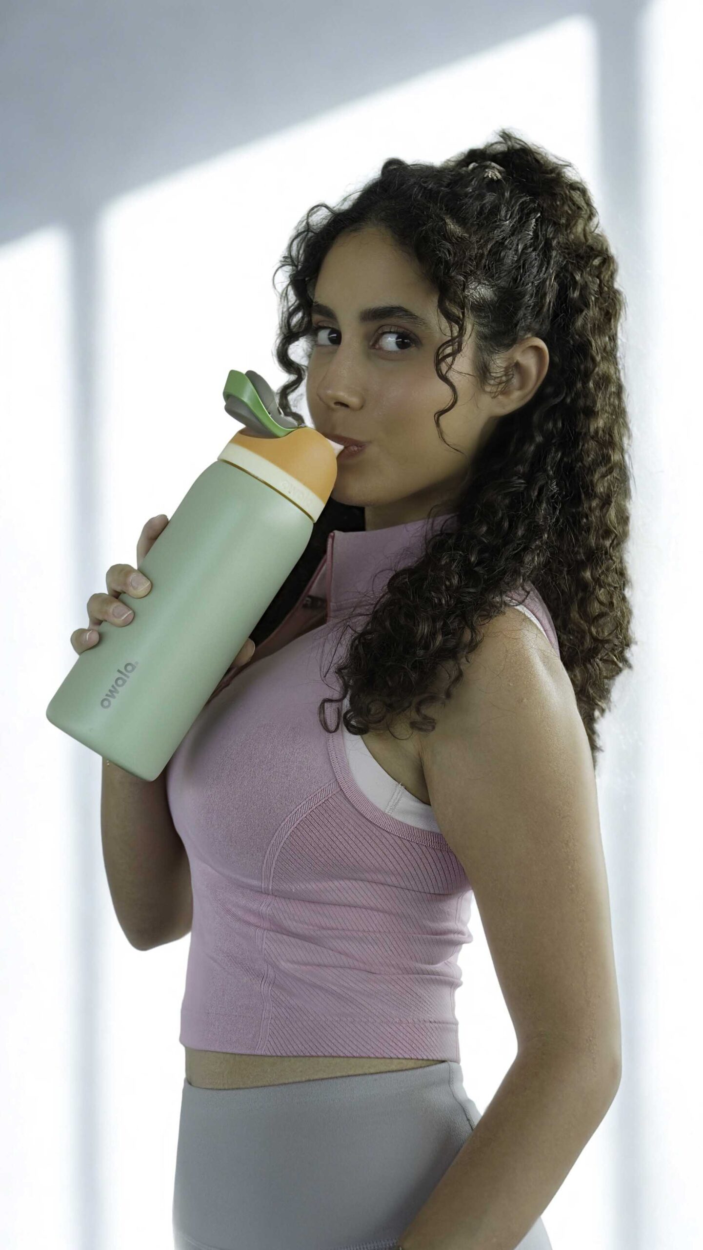 Nour fitness coach holding a water bottle.
